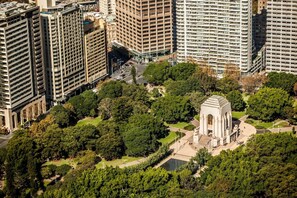A high-rise building complex with a central courtyard featuring a monument. - Little New York on Riley (Darlinghurst)
