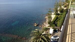 A coastal view with clear blue sea, rocky shoreline, and buildings along the cliff. - Solaria 1 and 2 - Ospedaletti Ligure - Lungomare C Colombo Nrfloor (Ospedaletti)