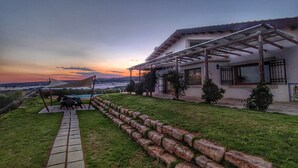 A house with a patio, a swimming pool, and a view of the sunset. - Studio Apartment in Countryside Villa With Swimming Pool (Ragusa)