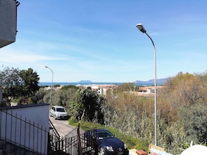 Un quartier résidentiel avec une rue, des voitures garées et un lampadaire.