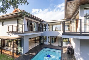 A modern two-story house with a swimming pool, large glass windows, and a wooden deck. - Zimbali by Euphoric, Zimbali Coastal Resort, Ballito (Ballito)