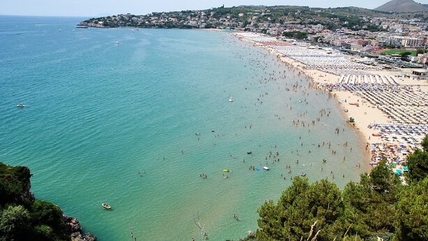 A coastal beach with clear waters, a sandy shore, and a town in the background. - Belvedere Home With sea View on the Gulf of Gaeta (Gaeta)