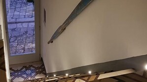 Un escalier orné d’un élément décoratif en métal sur le mur et doté d’un revêtement de sol à motifs.