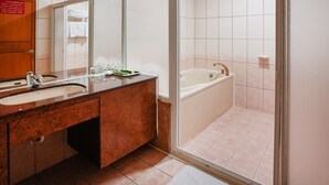 A modern bathroom with a double sink, a large mirror, a bathtub, and a glass shower enclosure. - Herkang Hotel (Taichung)