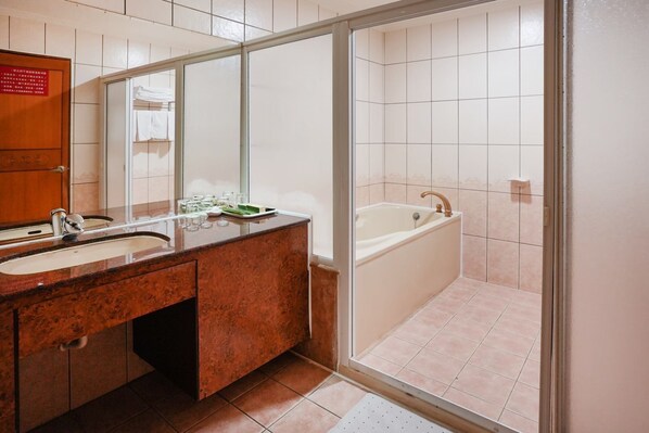 Un baño moderno con lavamanos doble, un espejo grande, una bañera y una cabina de ducha de vidrio.