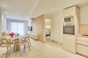 A modern hotel room with a dining area, kitchenette, and a bed. - Silken Atlantis Playa – Holiday Homes (Las Palmas de Gran Canaria)