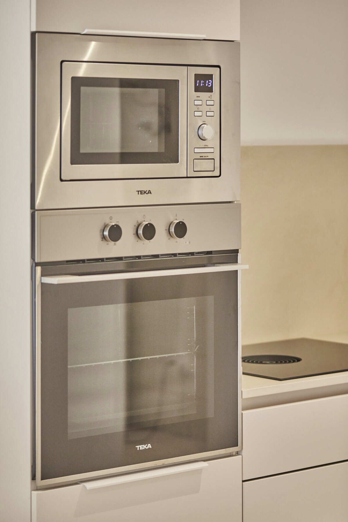 Cocina con horno y microondas integrados, con pantalla de reloj digital.