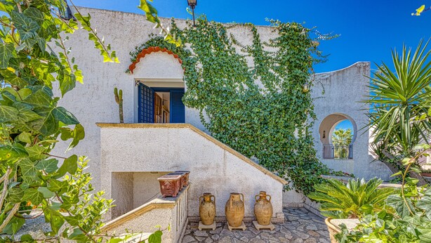A courtyard with a stone floor, a white building with blue shutters, and potted plants. - Room in Guest Room - Studio Monolocale Margherita With Sea View, Balcony & Wi-fi (Salve)