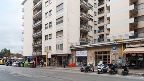 A multi-story building with balconies, a coffee bar, and a nail salon. - Studio Near San Pietro (Rome)
