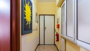 A hallway with a fire extinguisher, a door, and a window. - Studio Near San Pietro (Rome)