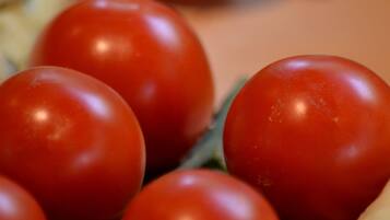 A close-up of cherry tomatoes on a wooden surface.