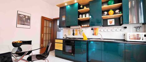 Cafetera o tetera, placa de cocina y mesa de comedor