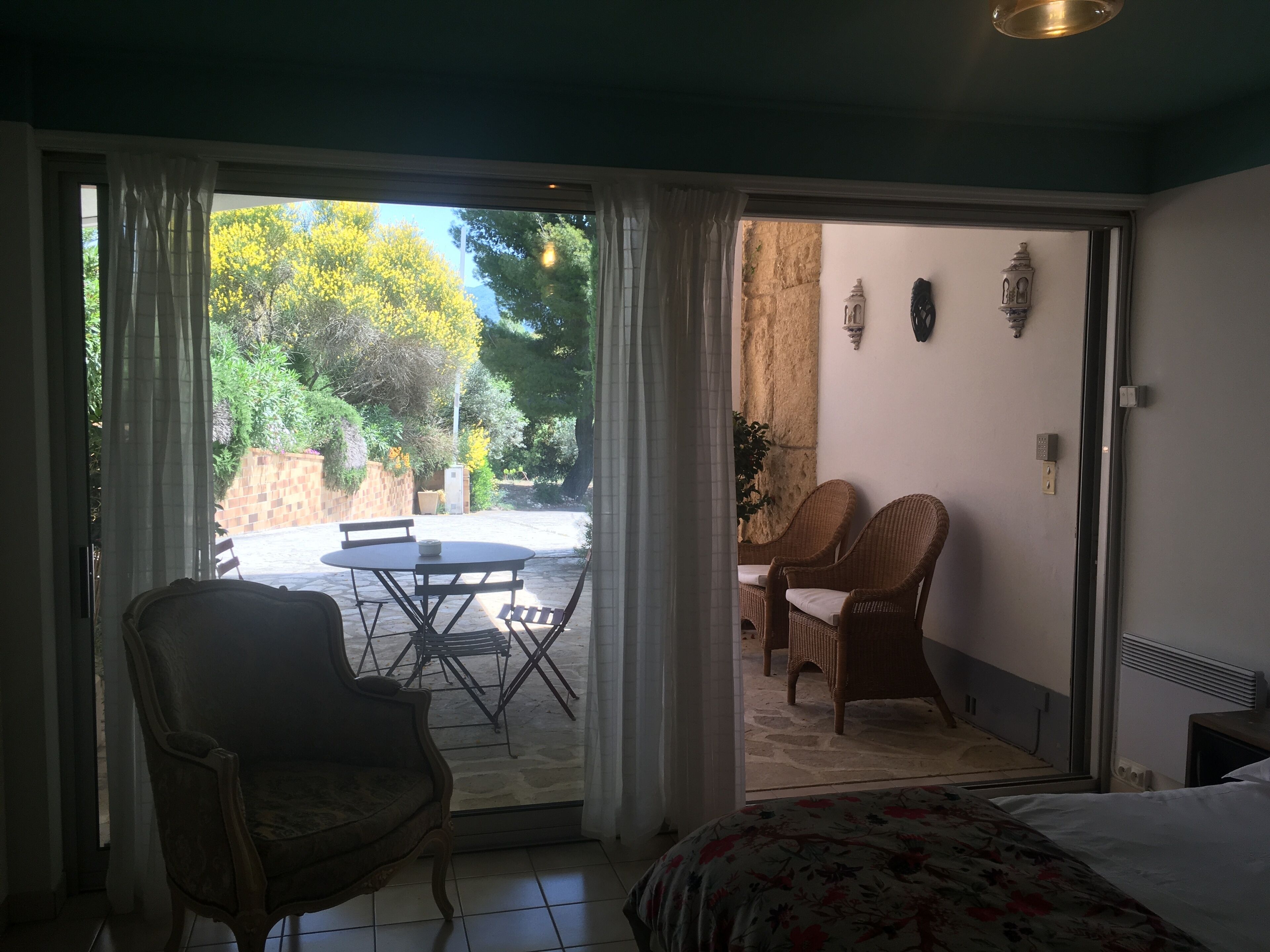 Una habitación con una cama, una mesa de comedor con sillas y vistas a un patio exterior con mesa y sillas.