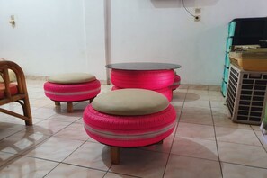 A room with a tiled floor, a wooden chair, and a table with a black top. - SPOT ON 2422 Kost Laguna (Palembang)