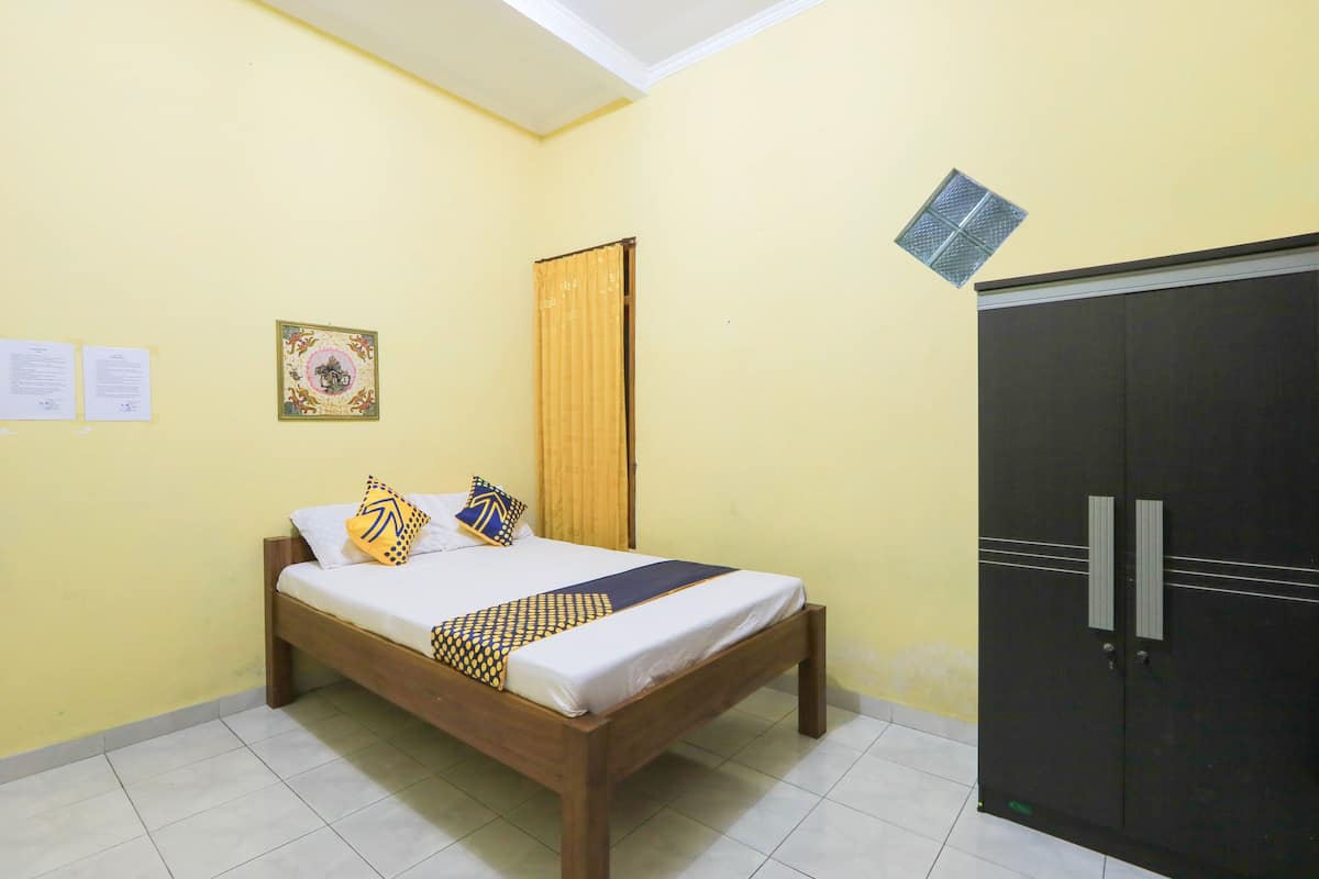 A room with a bed, a wardrobe, and a ceiling light.