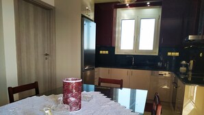 A dining area with a table set for two, a red vase, and a glass jar on a lace tablecloth. - Luxurious Villa Paradise PRIVATE BEACH (Faistos)
