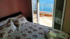 A bedroom with a bed, a window, and a view of the sea. - Luxurious Villa Paradise PRIVATE BEACH (Faistos)