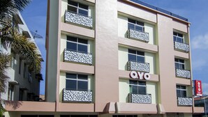 A multi-story building with balconies, a prominent 'OYO' sign, and satellite dishes. - OYO 2382 Wisata Hotel (Samosir)