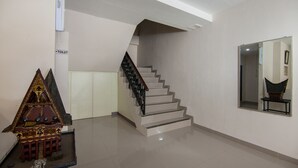 A staircase with a modern design, a small model house, and a mirror on the wall. - OYO 2382 Wisata Hotel (Samosir)