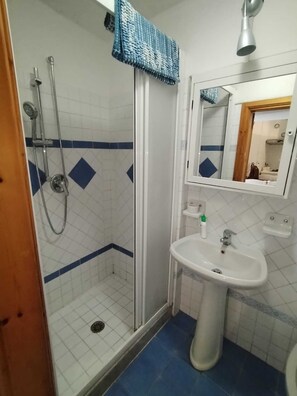 A bathroom with a shower, a sink, and a mirror. - Ischia Ponte Romantic Apartment in the Historical Center and Near the sea (Ischia)