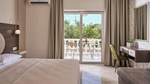 Une chambre d’hôtel moderne dotée d’un grand lit, d’un bureau, d’une chaise et d’un balcon offrant une vue sur la verdure.