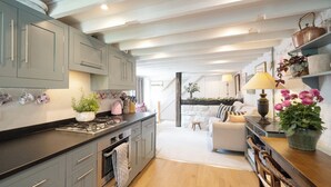 Una cocina moderna con armarios grises, encimera de madera y un comedor con mesa y sillas.