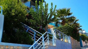A staircase leading to a modern building with stone walls and blue railings. - Luxurious Villa Ariadni Theseus Crete (Malevizi)