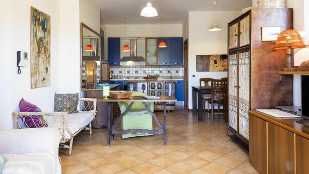A cozy living room with a dining area, a kitchen with blue cabinets, and a wooden reception desk. - Cosy apartment for 4 guests with A/C, pool, WIFI, TV, terrace and pets allowed (Sperlonga)