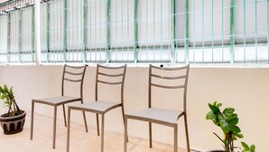 A seating area with four chairs and two potted plants. - OYO 2354 3 Point Residence (Surabaya)
