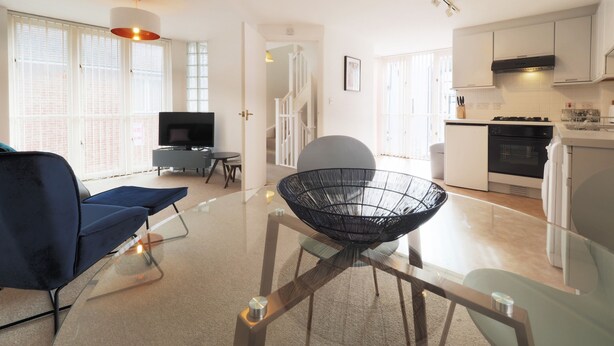 En moderne lejlighed med stue, spiseområde og køkken.