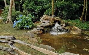Un paysage naturel avec une petite cascade, entouré de rochers et de verdure.