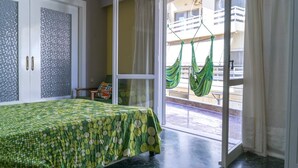 A room with a bed, a sliding glass door to a balcony, and a hammock hanging outside. - Cozy Flat Kika's Heraklion CITY CENTRAL (Heraklion)
