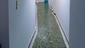 A hallway with a green speckled floor, white walls, and a teal archway. - Cozy Flat Kika's Heraklion CITY CENTRAL (Heraklion)