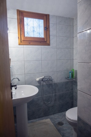 A bathroom with a window, a sink, a toilet, and a shower. - Luxury Maisonette, Big Yard (Chania)