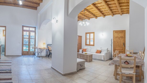 Amplia sala de estar con cocina, mesa de comedor y un rincón de descanso acogedor.