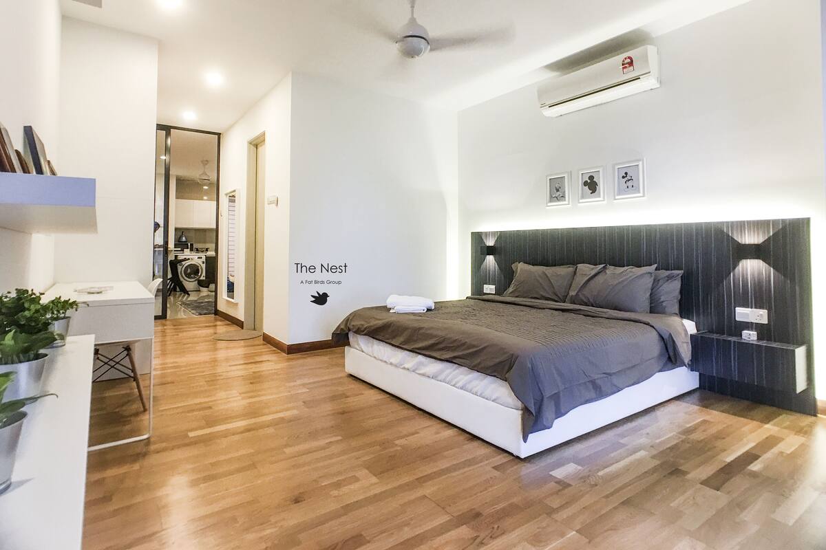 A modern bedroom with a bed, bedside tables, a ceiling fan, and an air conditioning unit.