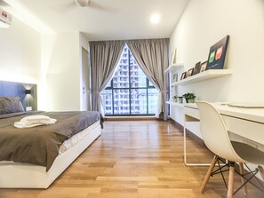 A modern bedroom with a large window, a bed, a desk, and a chair.