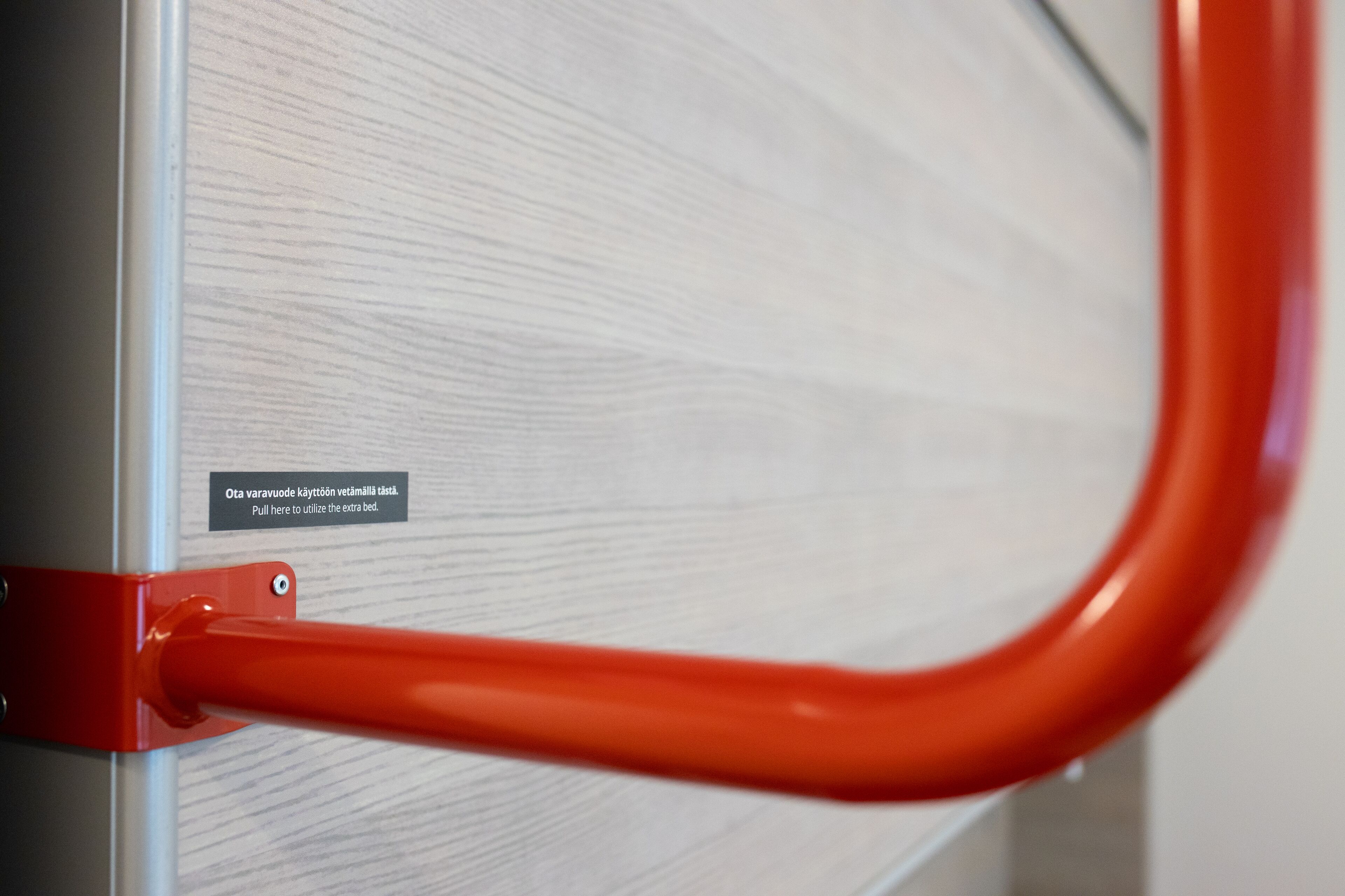 Un pomo rojo de metal sujeto a la pared con una etiqueta.