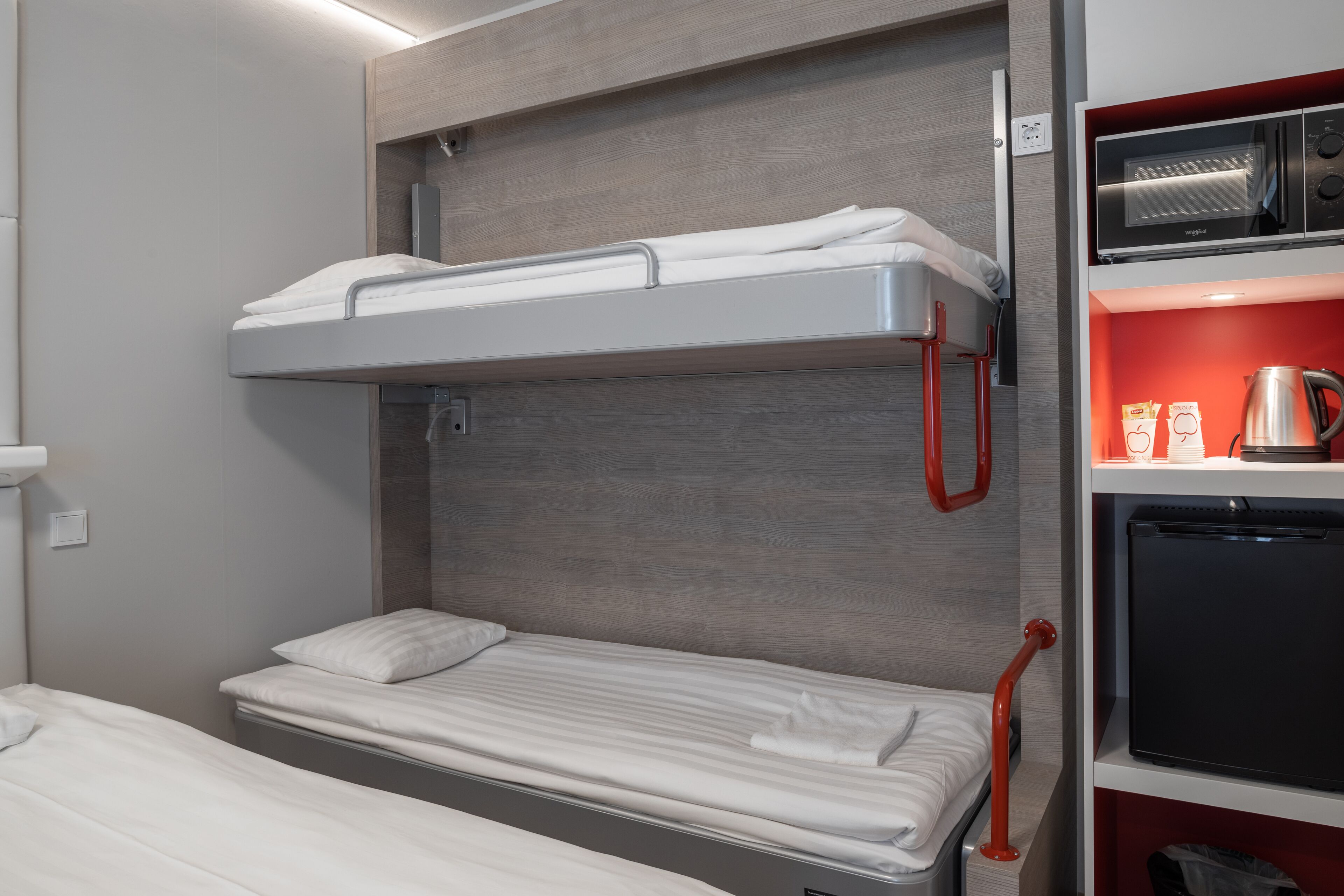 Una cama litera con una cama inferior y un microondas arriba.