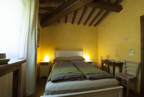 Ein Schlafzimmer mit einem Bett, Nachttischen, einem Sessel und einem Beistelltisch.
