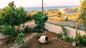 A garden with a variety of plants, a stone pathway, and a large pipe. - Luxury Villa Zen Amazing View Near The Sea (Hersonissos)