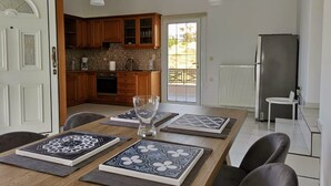 A modern kitchen with wooden cabinets, a built-in oven, and a large window. - Luxury Villa Zen Amazing View Near The Sea (Hersonissos)