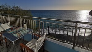 A balcony with a table and chairs overlooking a coastal view. - Amazing House Erato On The Sea South Creta (Archanes-Asterousia)