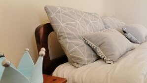 A neatly made bed with a white comforter and several pillows, including a geometric patterned one. - Amazing House Erato On The Sea South Creta (Archanes-Asterousia)