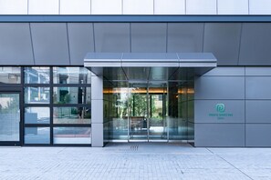 The exterior of a modern building with a glass entrance, a sign for Prince Smart Inn Ebisu, and a paved walkway. - Prince Smart Inn Ebisu (Tokyo)