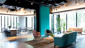 A modern office space with a large open area, several chairs, a sofa, and a coffee table. - Prince Smart Inn Ebisu (Tokyo)