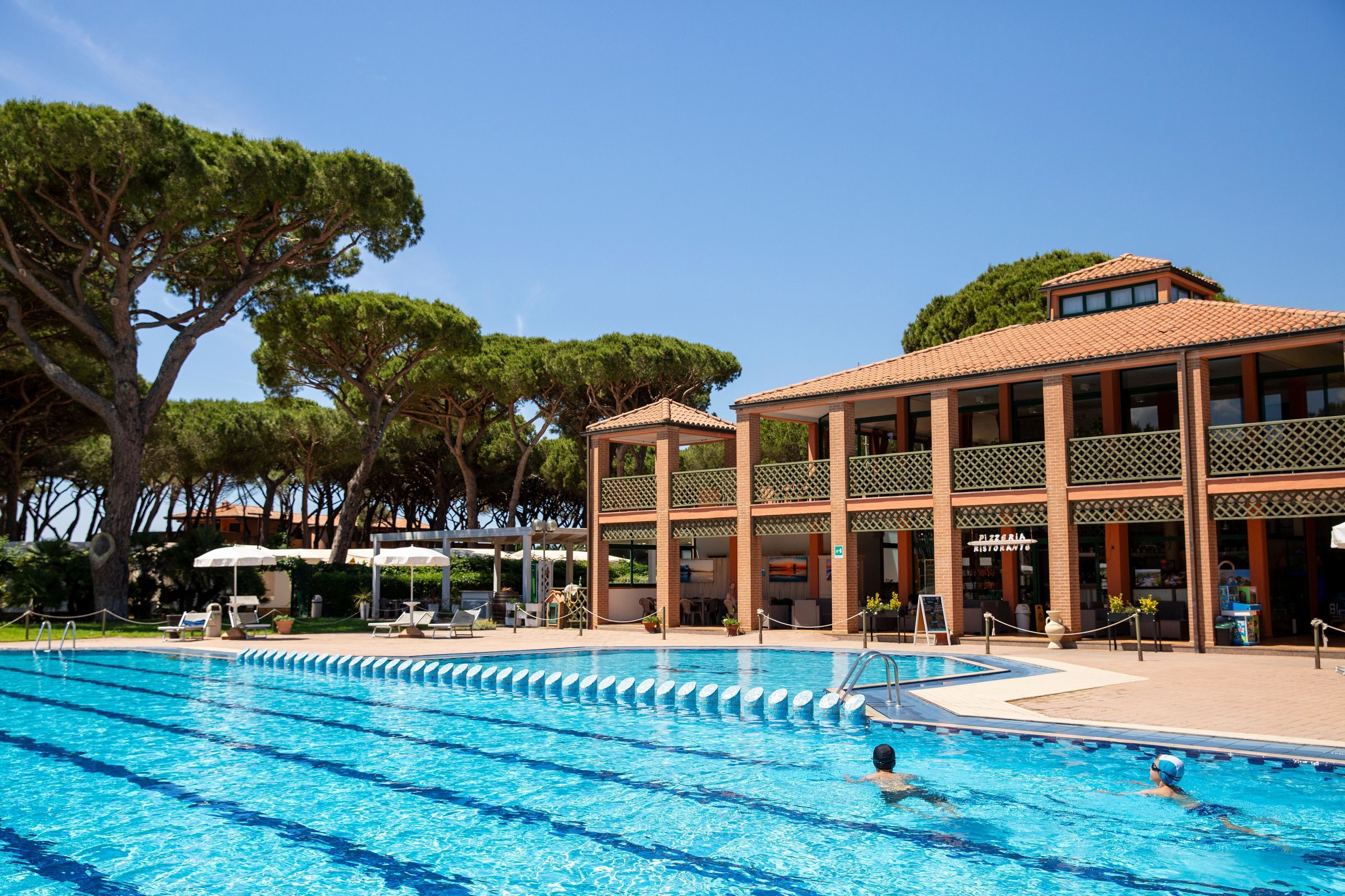 Une piscine à l’eau d’un bleu cristallin, entourée de chaises longues et de parasols.