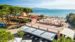 Terraza en la azotea con asientos al aire libre, con vistas a una playa y al mar.