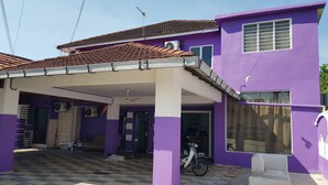 Ein zweistöckiges Gebäude mit violetten Wänden und einem Ziegeldach.