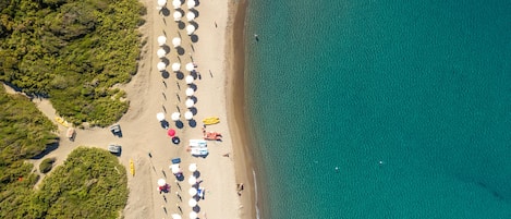 Plage privée, sable noir, chaises longues, parasols
